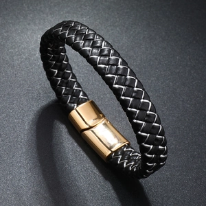 Close-up of black braided leather bracelet with polished gold magnetic metal clasp