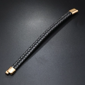 Detail of black braided leather men's bracelet with a polished gold magnetic clasp