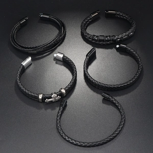 Macro view of five-piece set featuring braided black leather bracelets with alloy magnetic clasps