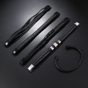 Macro detail of multilayer black leather woven bracelet set with metal magnetic clasps