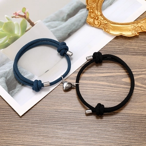 Detailed view of woven bracelets with magnetic heart charm clasp for couples and friends