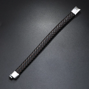 Close-up of men's black leather woven bracelet with red copper threads and silver buckle
