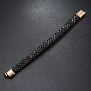 Macro detail of men's black woven leather bracelet with golden magnetic clasp and copper threads