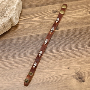 Vintage Lederarmband mit Silberperlen und Bronze-Druckknöpfen auf Holz Hintergrund Textur