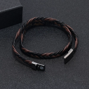 Detailed close-up of dual-tone leather braided bracelet with gunmetal magnetic clasp