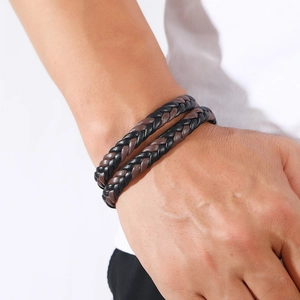 Detail shot of multi-layer black and brown braided leather bracelet with magnetic clasp