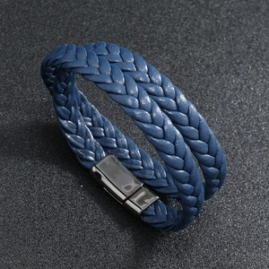 Detail of blue leather braided bracelet with black magnetic clasp on textured dark background