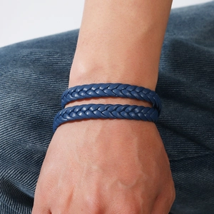Detailed view of dark blue braided leather double-layer bracelet worn on wrist