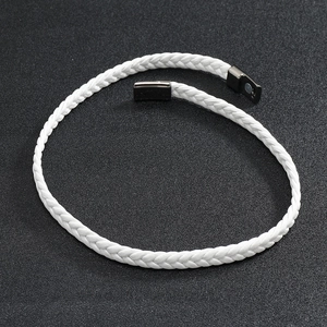 Detailed close-up of white braided leather bracelet with black magnetic clasp