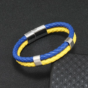 Détail du bracelet en cuir tressé bleu et jaune avec fermoir magnétique gravé