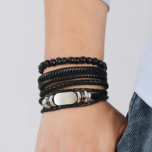 Detail of men's multilayer hand-woven leather bracelet set in black with silver charms