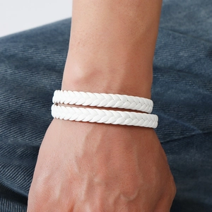 Close-up of a white braided leather wrap bracelet with magnetic clasp on a male wrist