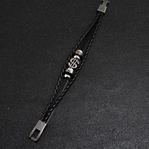 Detail of multi-layer braided black leather bracelet with silver dollar sign and metal clasp
