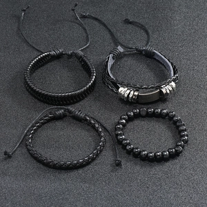 Detail of 4-piece vintage black braided leather bracelet set with beads and metal charms