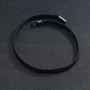 Macro shot of multi-layer black braided leather bracelet with glossy magnetic clasp