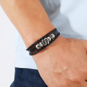 Men's multilayer black braided leather bracelet featuring a silver dollar sign metal charm