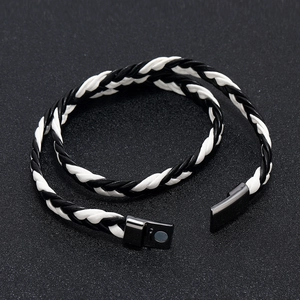 Detail of the dual-strand woven leather bracelet with a dark grey magnetic metal clasp