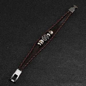 Detailed close-up of dark brown braided leather bracelet with silver dollar sign charm