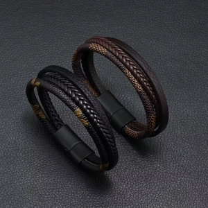 Detalle de pulseras de cuero trenzado multicapa con textura de damero y cierre magnético