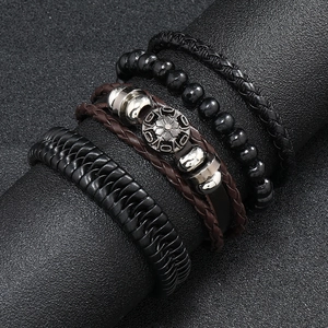 Close-up of men's vintage multi-layer leather bracelets and beaded set on black display