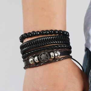 Close-up of men's vintage multi-layer braided leather bracelet with wooden beads and charms