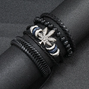Detail view of multi-layer leather bracelet with metal leaf charm and black beads