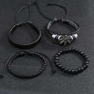 Close-up of four-piece vintage black leather bracelets with silver leaf pendant detail