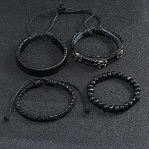 Detail of four-piece black leather wrap bracelet set with skull charm and beads