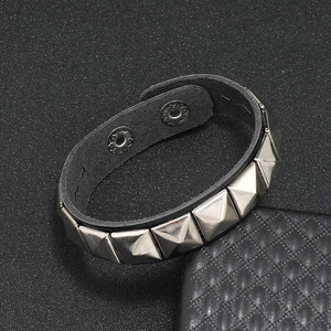Detail of punk black leather wristband with silver square pyramid studs and snap buttons