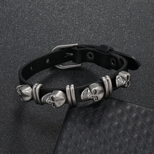 Detail of a men's punk leather bracelet featuring vintage silver skull studs and buckle