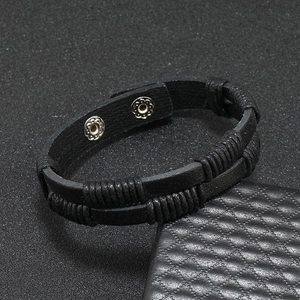 Detail of black woven leather bracelet showing double-layer structure and silver snap buttons