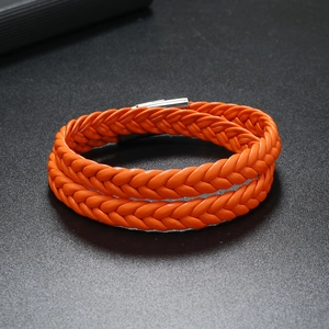 Detail view of double-wrap orange braided leather bracelet with silver magnetic clasp