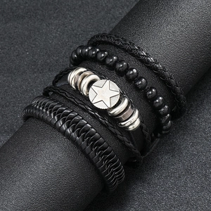 Close-up of vintage black multilayer braided leather bracelets with silver star charm