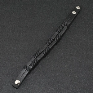 Detail view of black woven leather bracelet showing adjustable silver metal snap fasteners