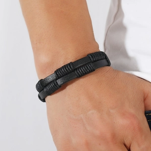 Detail view of men's multi-layer black braided leather bracelet on wrist