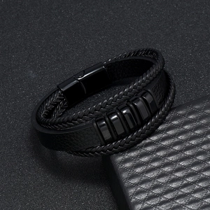 Detalle de la pulsera multicapa de cuero trenzado con cuentas negras y cierre magnético