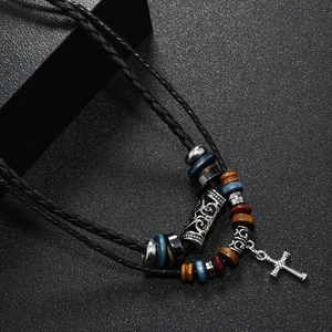 Détail du collier multicouche vintage avec pendentif croix en argent et perles en bois