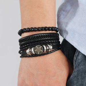 Close-up of men's layered black leather bracelet with vintage star charm and beads
