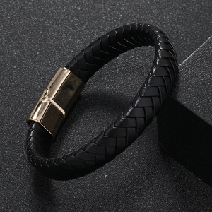 Close-up of men's braided leather bracelet featuring a polished gold magnetic metal clasp