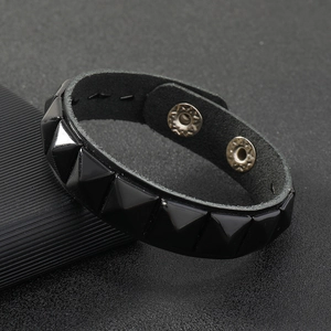 Detail of punk black leather wristband with pyramid rivets and double snaps