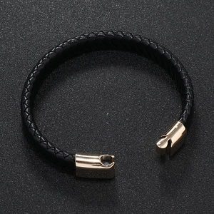 Close-up of black braided leather bracelet with a gold-plated magnetic metal clasp