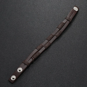 Detail of vintage brown leather woven bracelet with adjustable silver metal snap fasteners
