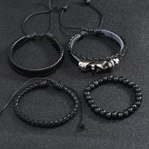 Detail of four-piece black punk braided leather bracelets with star charms and beads