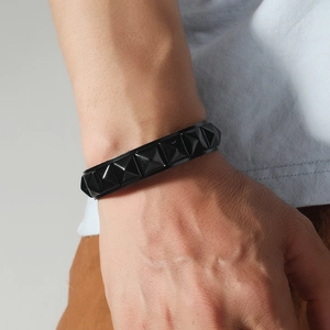 Punk black leather wristband featuring a single row of square pyramid studs for men