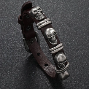 Macro shot of punk leather bracelet with metal skulls and adjustable belt buckle strap