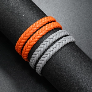 Detail of woven leather bracelets in orange and gray with magnetic clasp texture