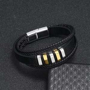 Detalle de pulsera multicapa de cuero trenzado para hombre con cierre magnético plateado y aros