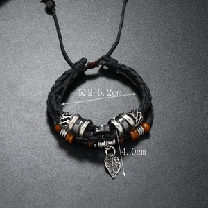 Detail view of woven leather bracelet with silver leaf pendant and vintage beads