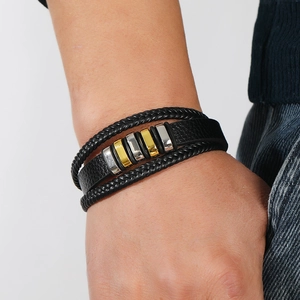 Detalle de la pulsera multicapa de cuero para hombre con cuentas de metal en oro y plata