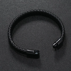 Minimalist black braided leather bracelet with magnetic metal clasp for men on dark background